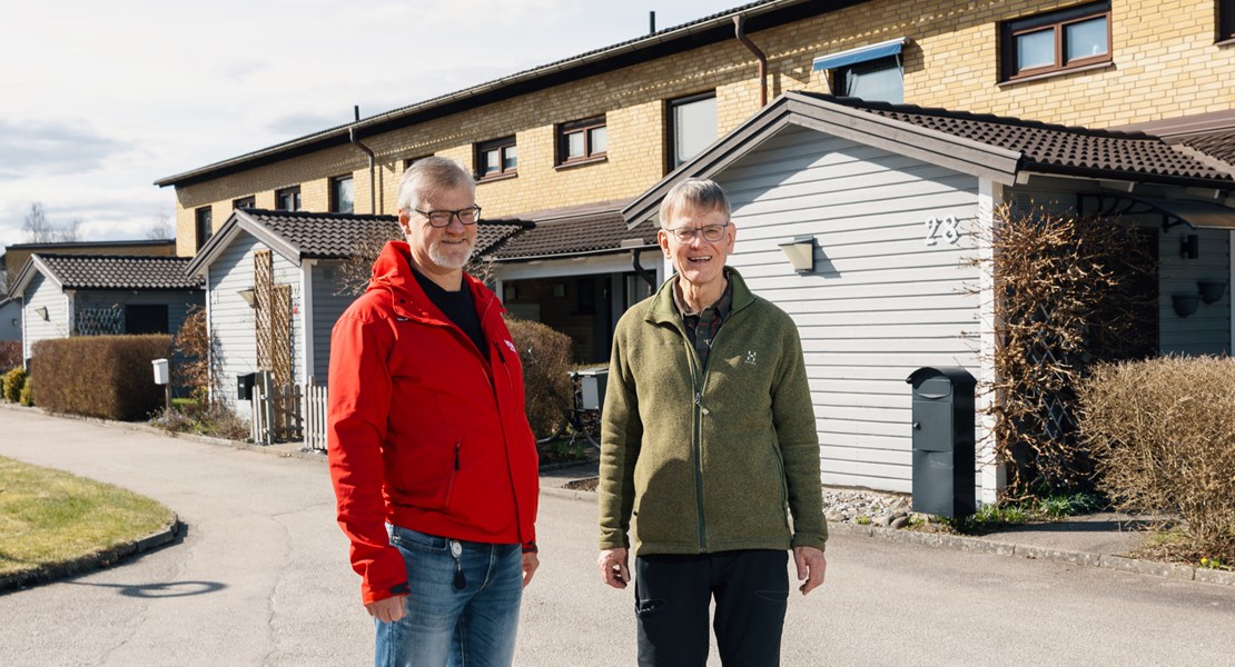 Sven och Klas står utomhus vid radhus och ler mot kameran. 