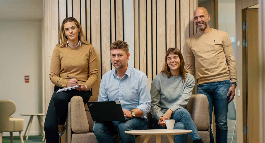Fyra anställda på Växjö Energi står på rad i kontorsmiljö och tittar mot kameran.