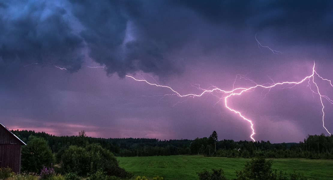Mörkt lilafärgad himmel som lyses upp av en blixt.