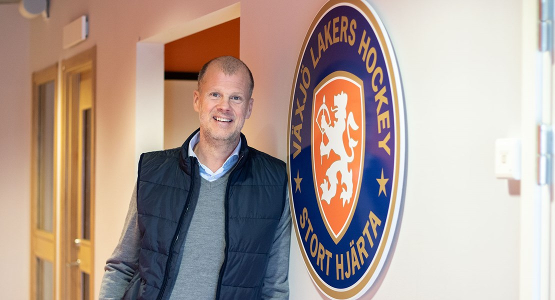 Fredrik Sandberg står lutad mot en vägg där Växjö Lakers logotyp är synlig.